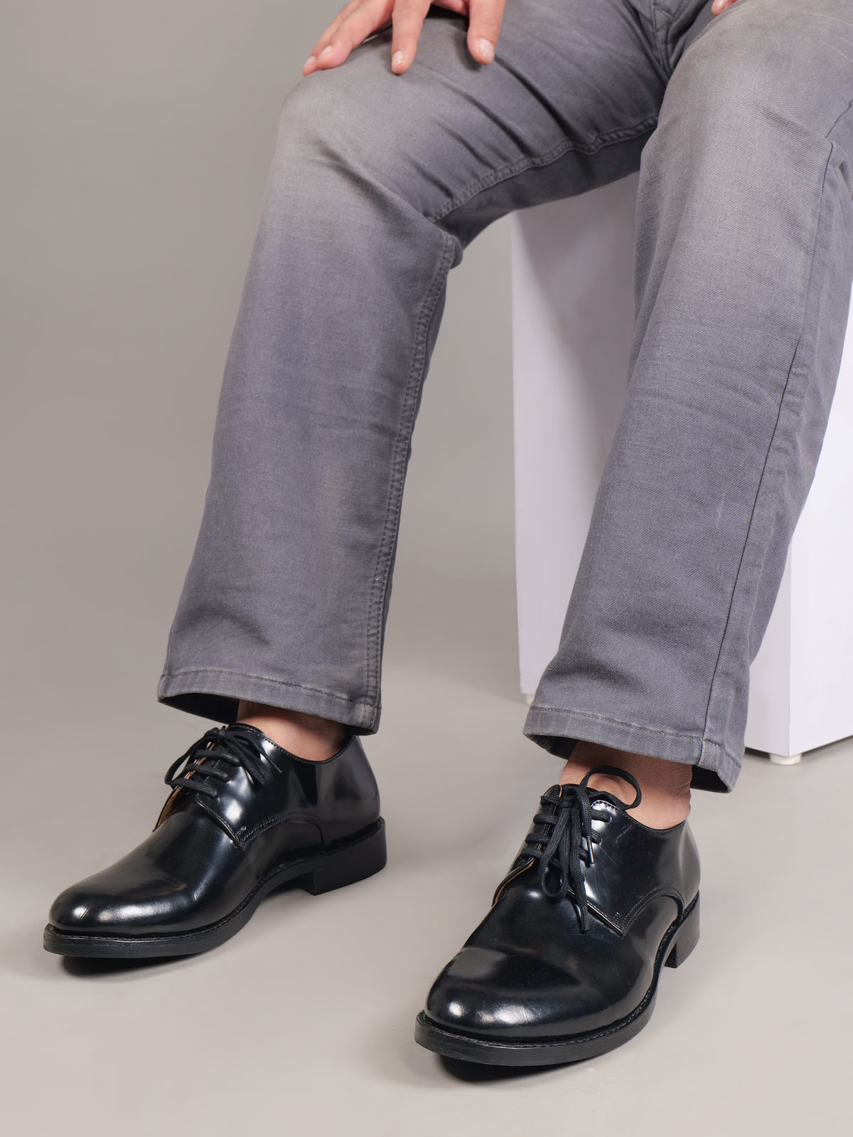 Black Blucher Goodyear welted leather shoes worn with gray trousers