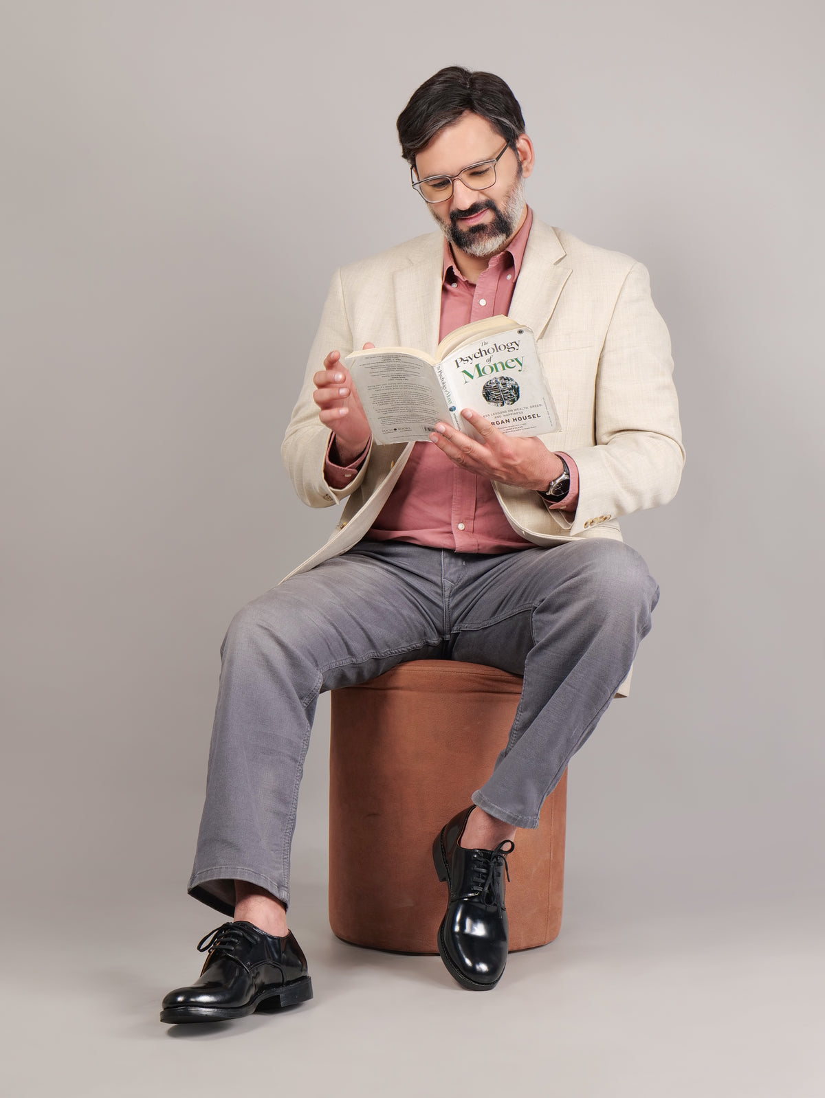 Male model sitting and reading while wearing black Blucher Goodyear welted leather shoes
