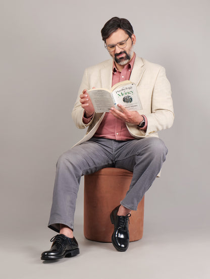 Male model sitting and reading while wearing black Blucher Goodyear welted leather shoes