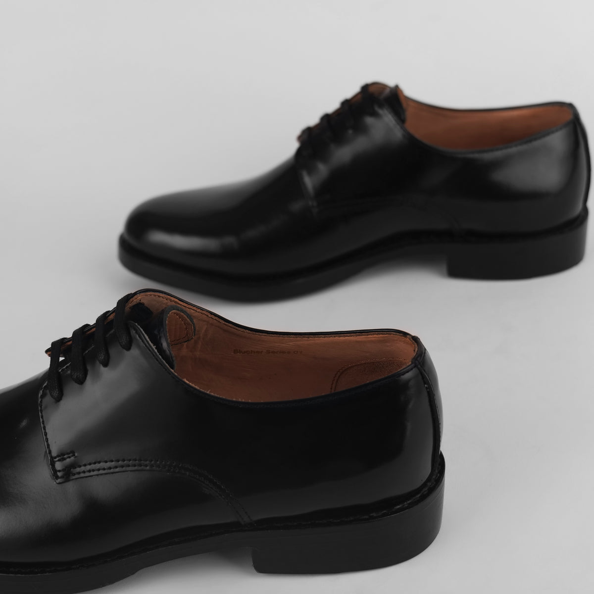 Back heel view of black Goodyear welted Blucher shoes with visible welt stitching