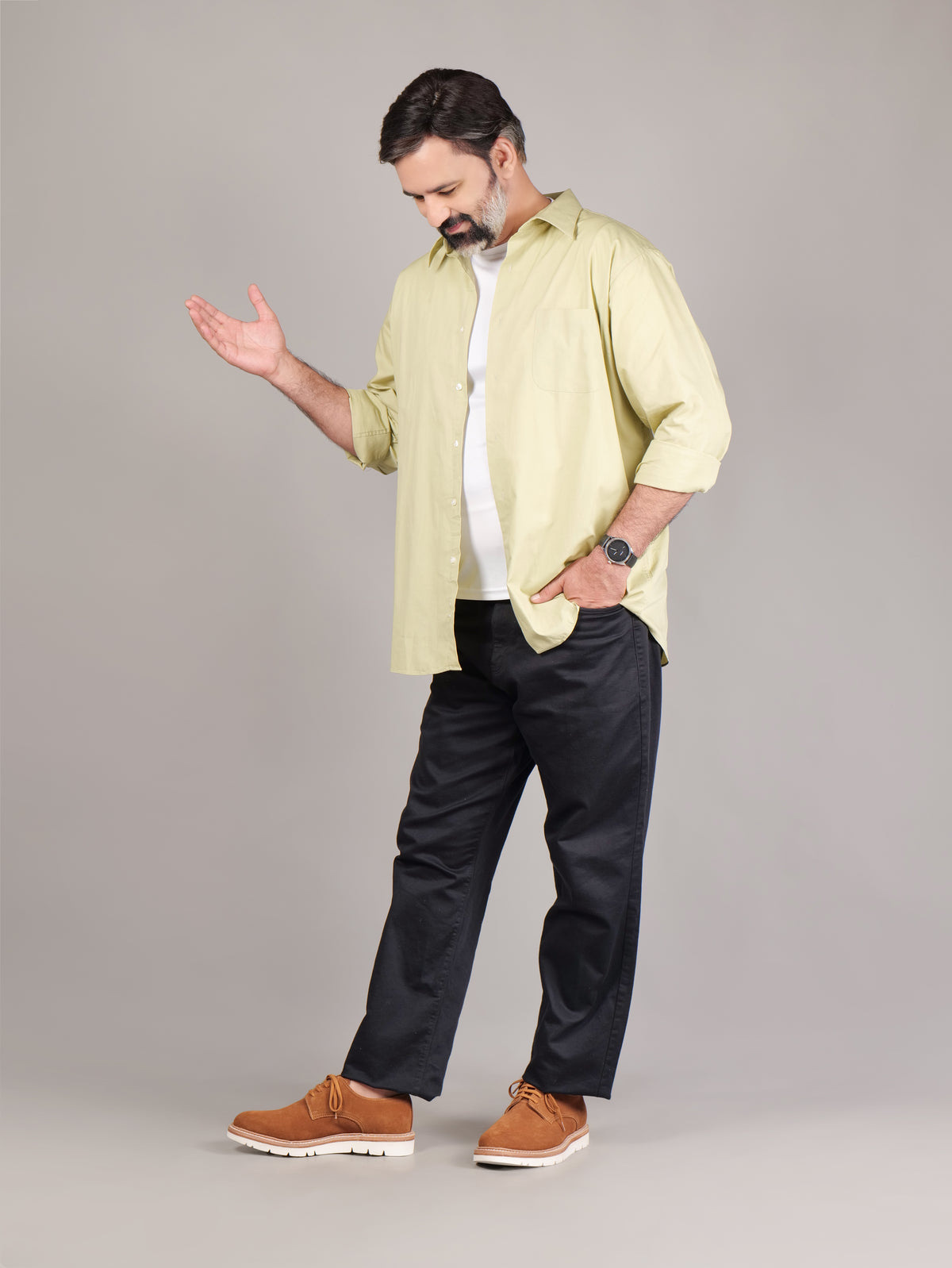 Male model wearing brown Blucher Suede shoes while standing against a beige studio background