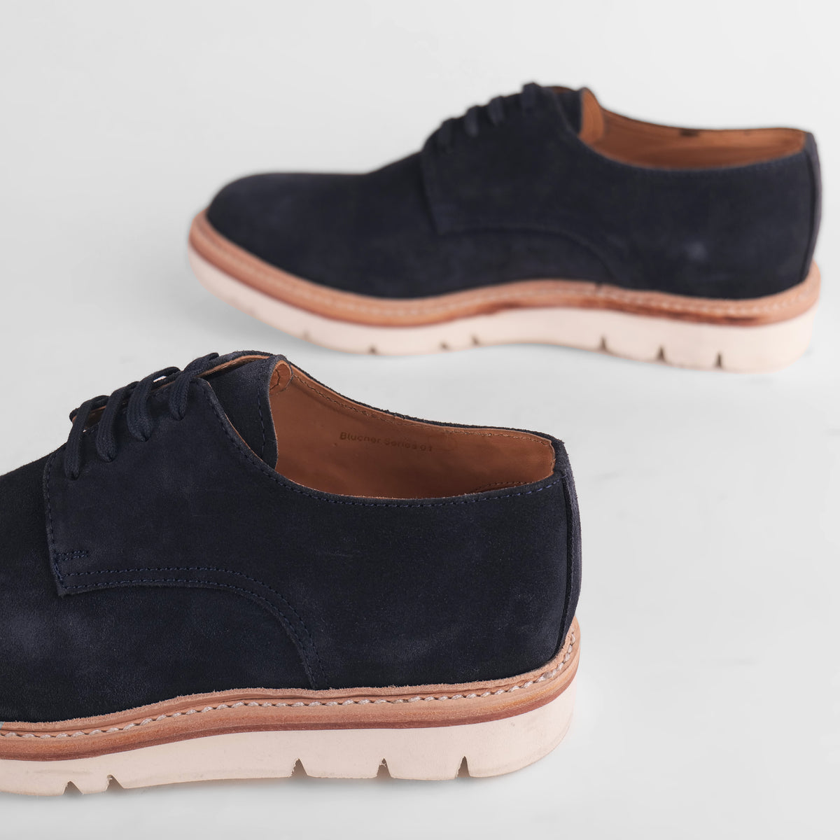 Side view of a pair of navy blue Blucher Suede shoes
